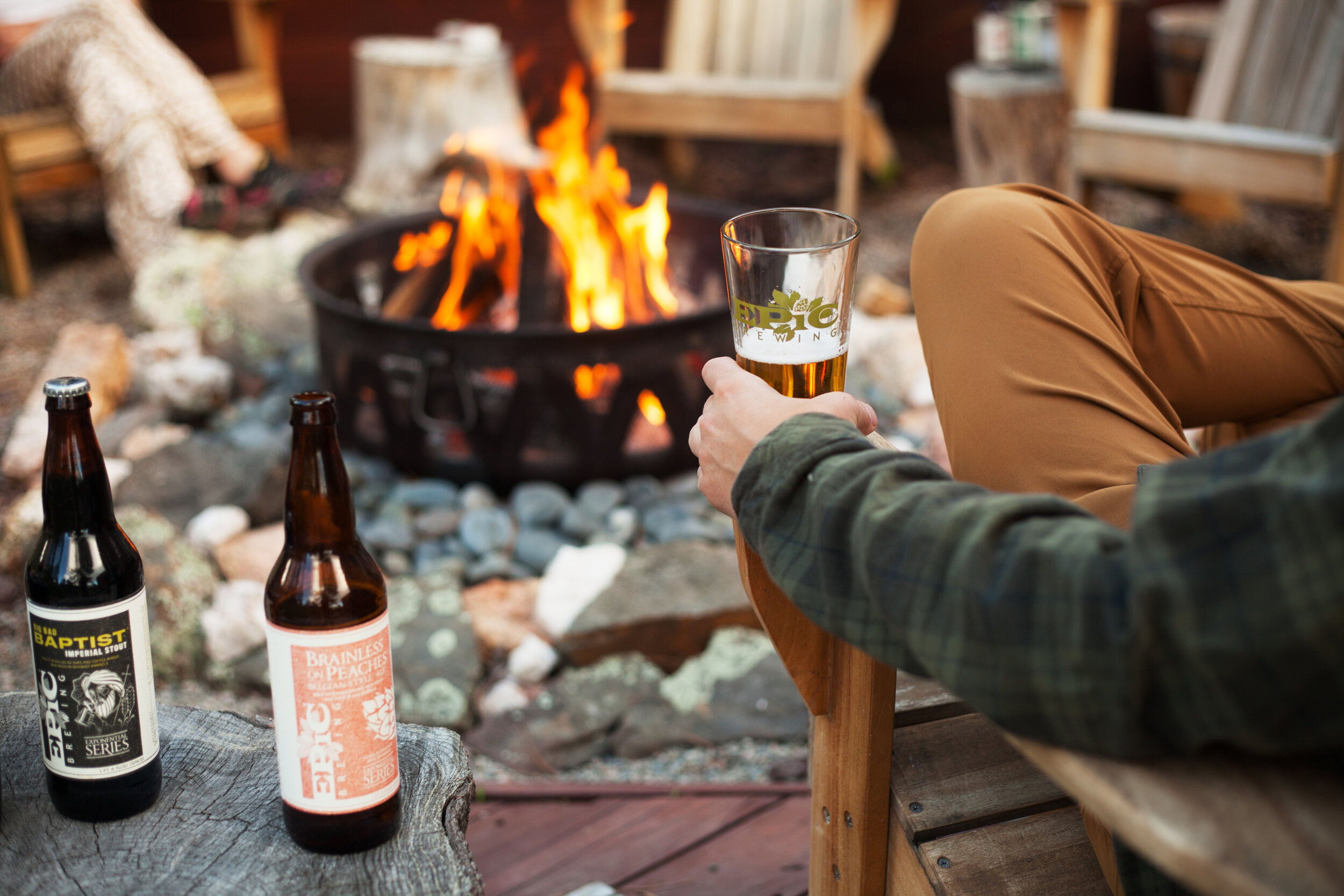 Several friends enjoy the Big Bad Baptist Imperial Stout and Brainless on Peaches Belgian Ale around a campfire